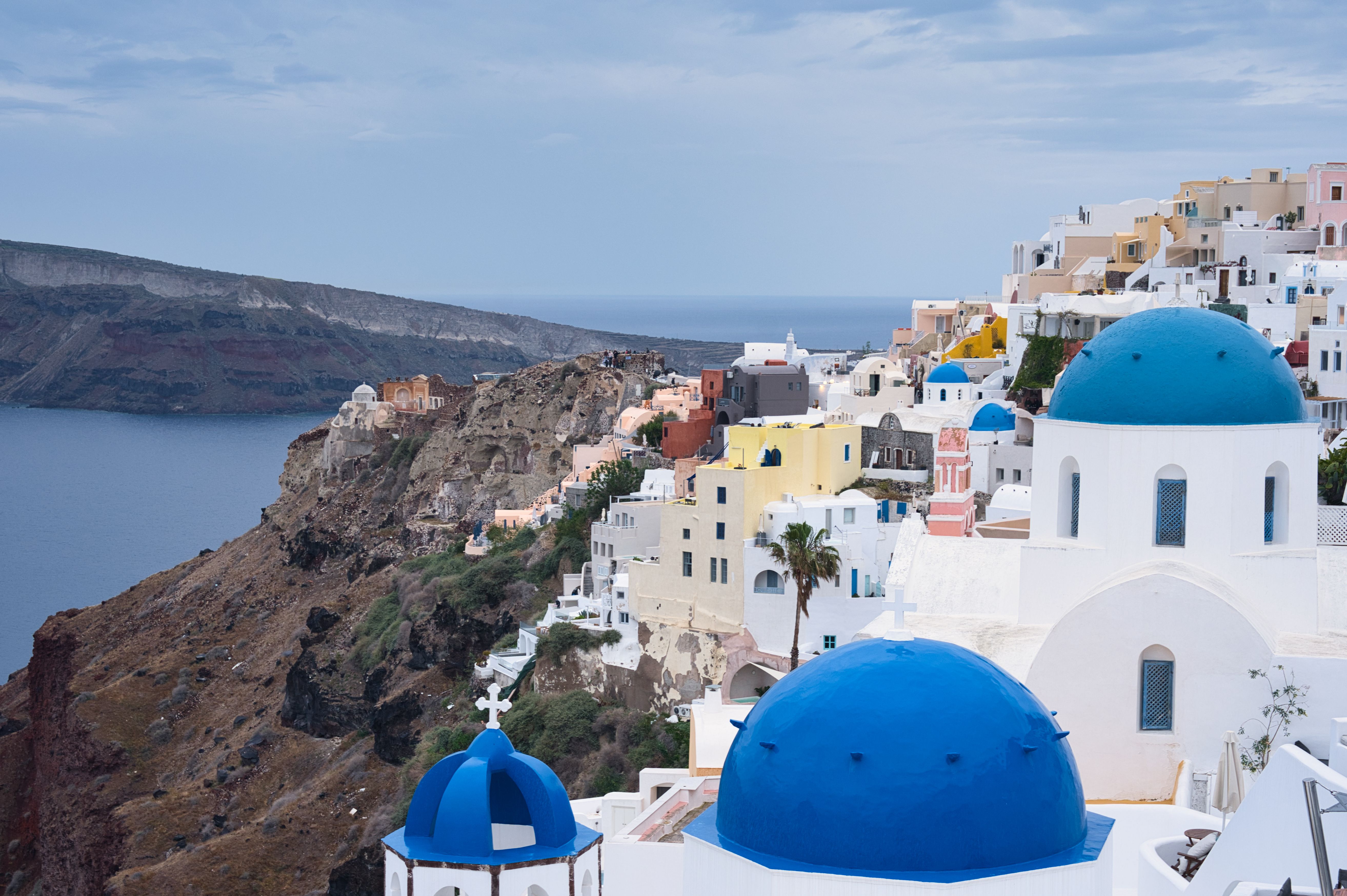 Oia Santorini white buildings blue dome sunset caldera view