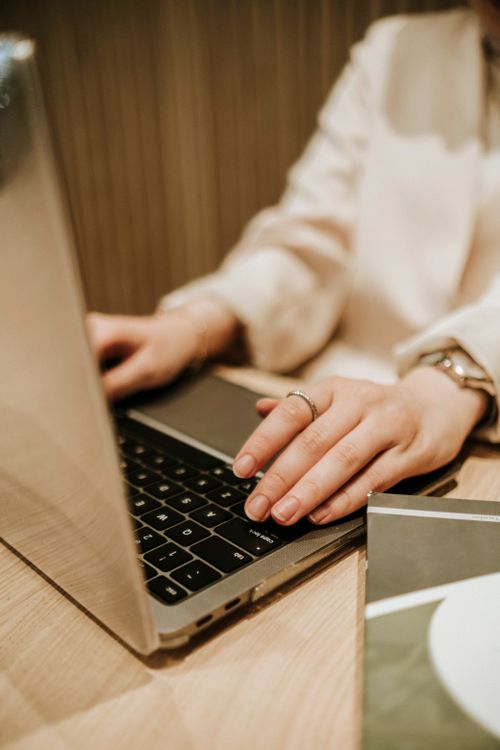 Free Close-up of a woman typing on a laptop keyboard, showcasing modern technology in use. Stock Photo