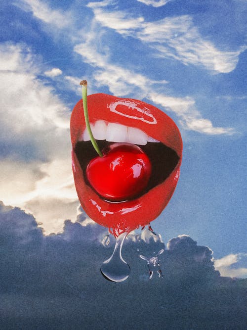Cherry in Mouth against Cloudscape