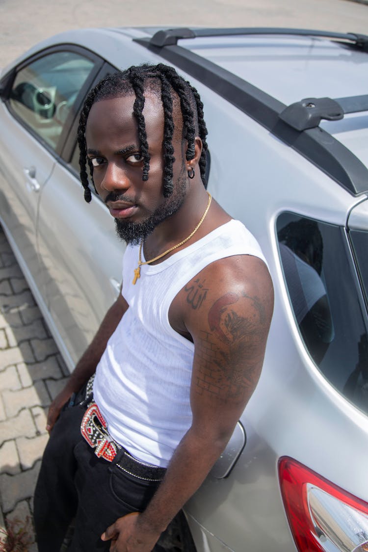 African Man Standing Next To A Car