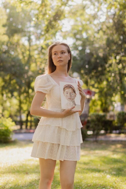 Blonde Woman with Portrait Painting in Hands