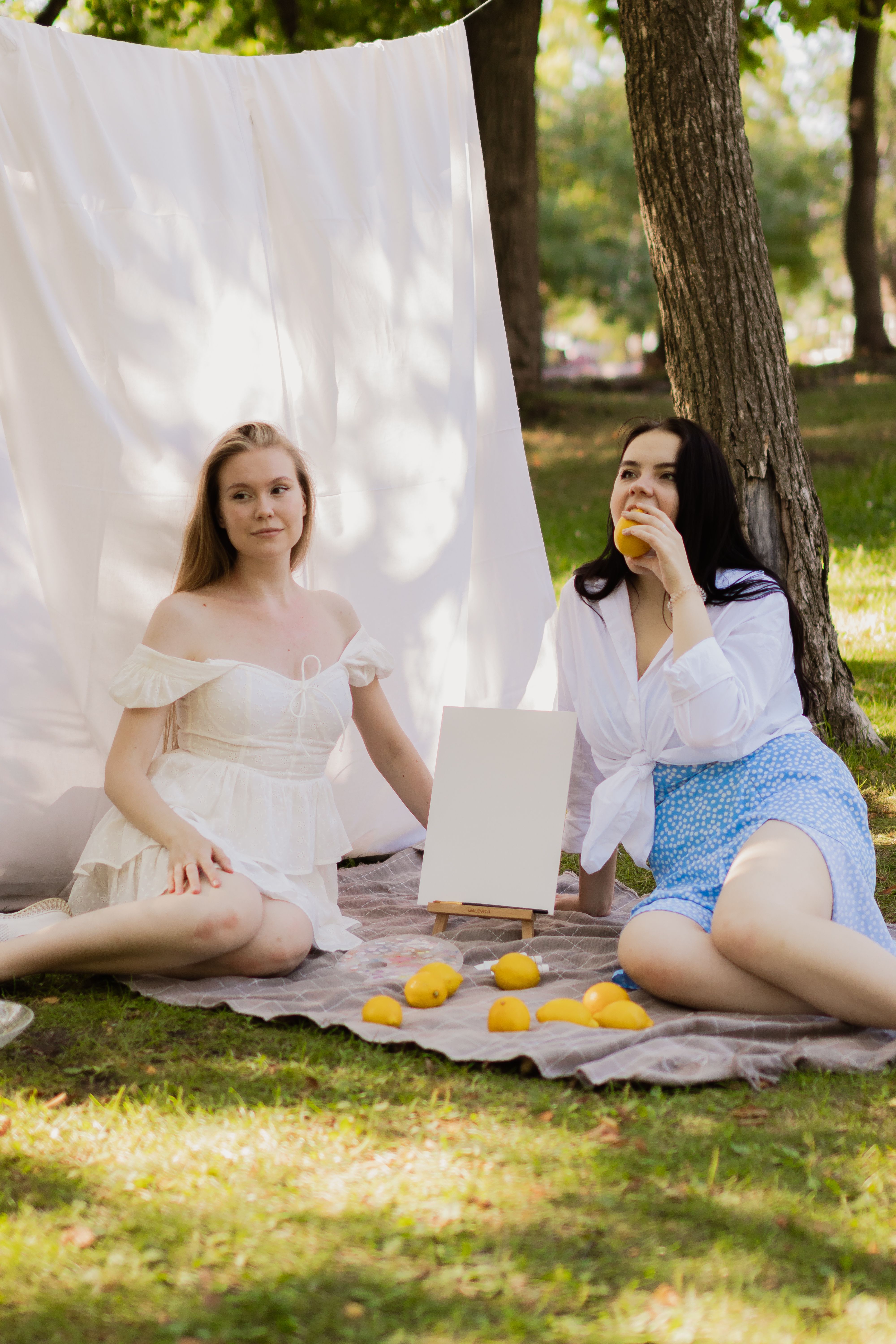 Two Young Women Posing on a Park Lawn · Free Stock Photo