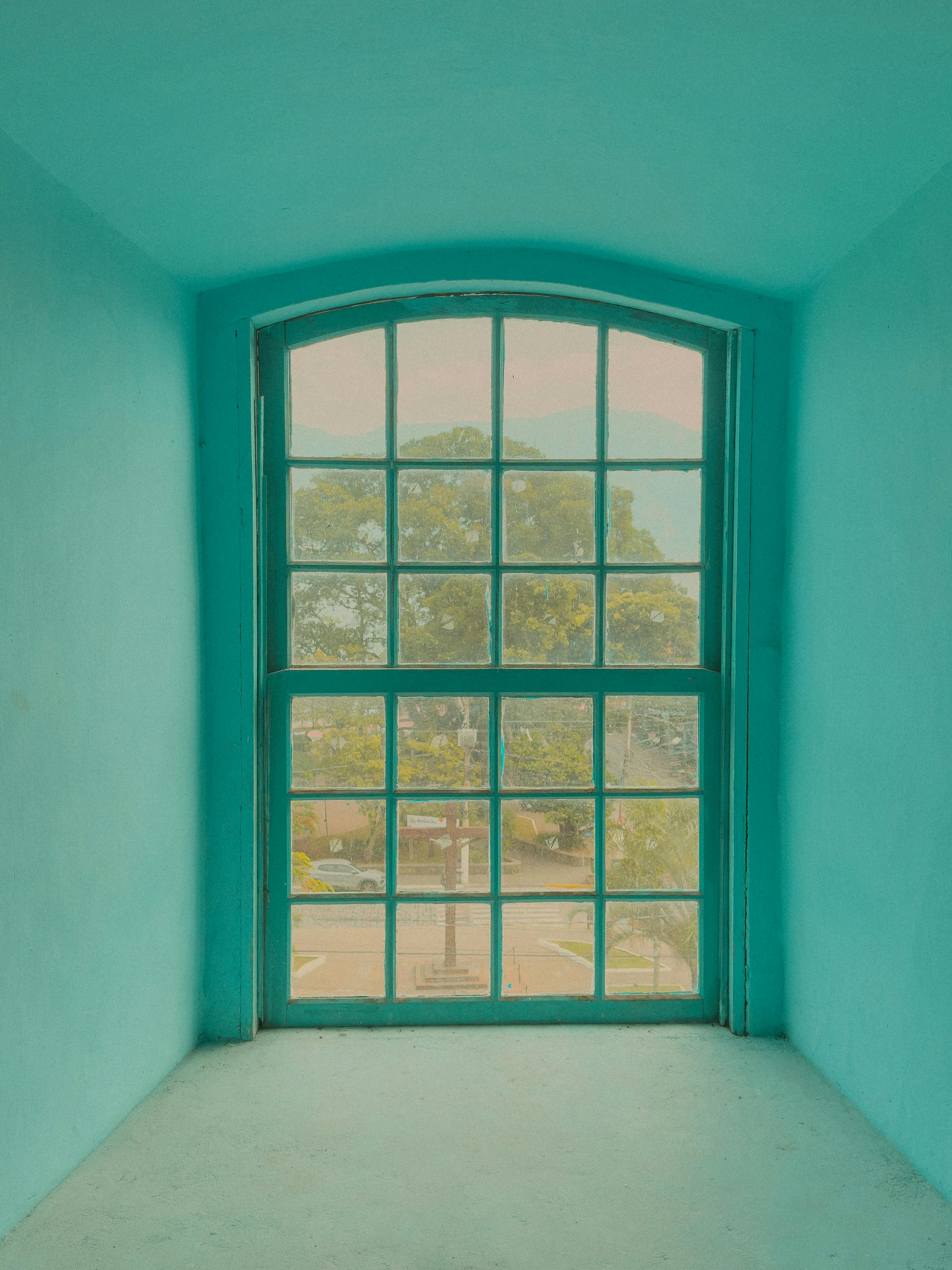 Peaceful view through a green-tinted window in Ilhabela, Brazil, showcasing nature and tranquility.
