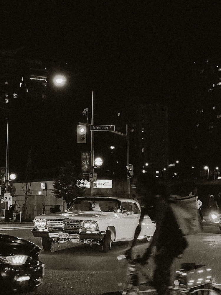 Vintage Car Riding On A Street In Black And White