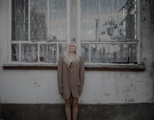Woman in Coat and with Dyed, Gray Hair Posing by Windows