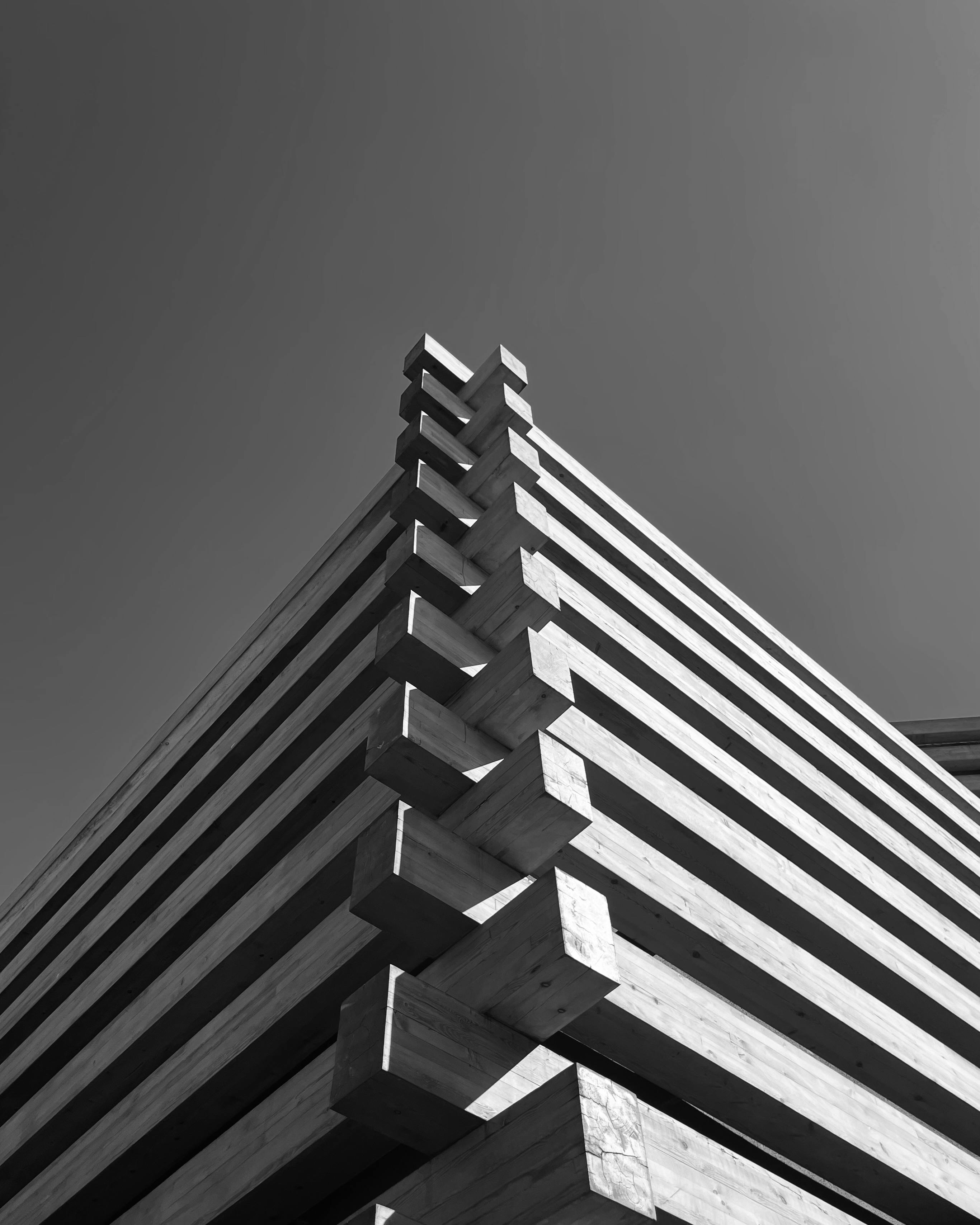 Free Low angle view of a modern wooden facade under a clear sky, showcasing architectural lines. Stock Photo