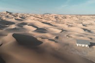 A desert with a small house in the middle