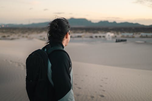 A person with a backpack looking at the desert