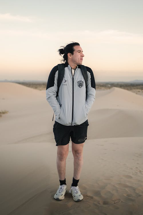 A man in a jacket standing in the desert
