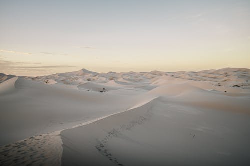 A desert landscape with sand dunes and a sky