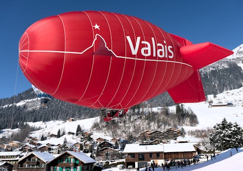 A Hot Air Airship Flying above the Valley Covered in Snow 