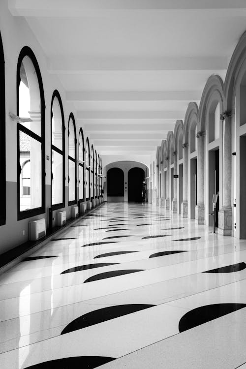 Black and White Photograph of a Corridor with a Marble Patterned Floor