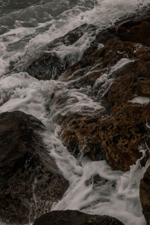 Free Close-up of foamy waves crashing against rocks in Laigueglia, Liguria, Italy. Stock Photo