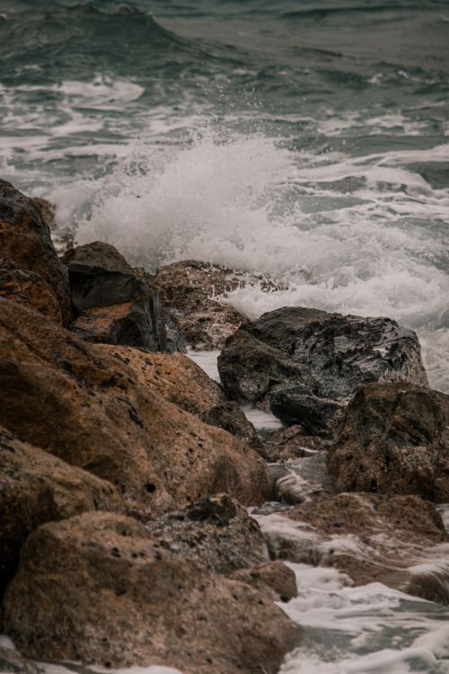 Free Dynamic waves crash against rugged rocks on the Laigueglia beach in Liguria, Italy. Stock Photo