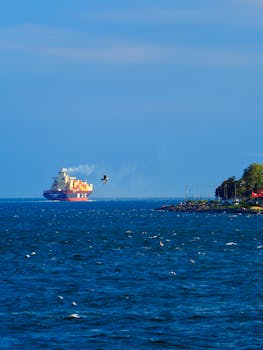 A cargo ship sails near the coast of Istanbul, Turkey, under a clear blue sky.