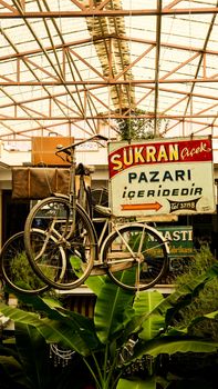 Bicycle hanging as decoration under market roof, showcasing urban aesthetics.