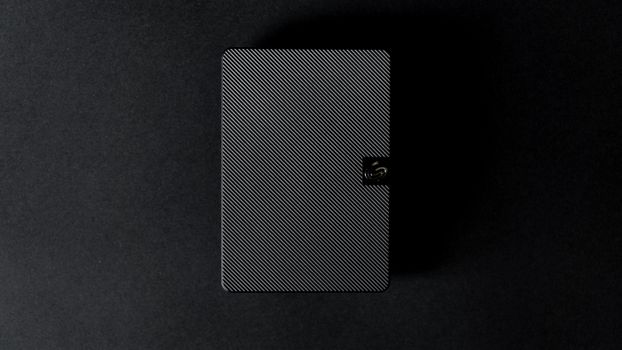 Close-up of a sleek external hard disk against a black backdrop, showcasing modern technology design.