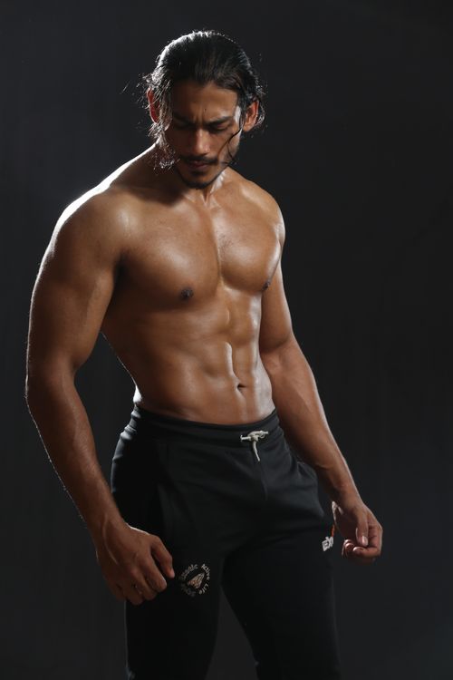Free A muscular man posing shirtless in a studio shoot, showcasing fitness and strength. Stock Photo