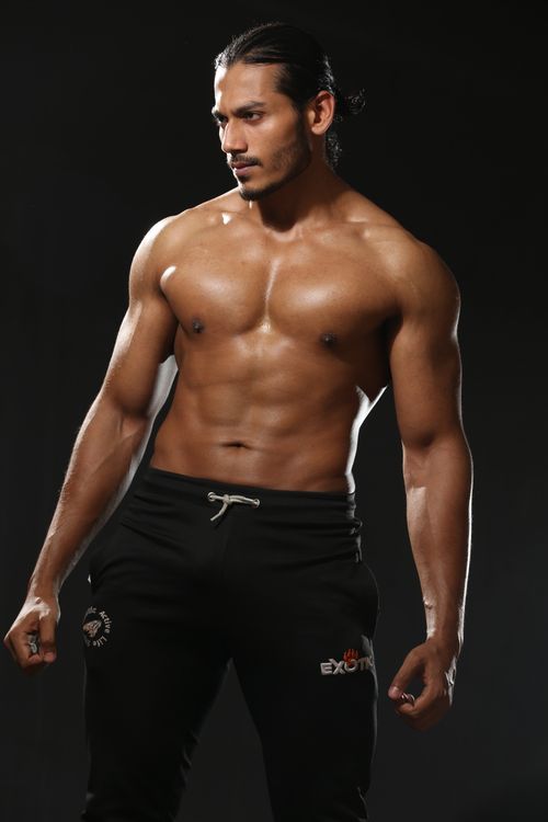 Free Muscular male model posing shirtless in sportswear, highlighting fitness and strength. Stock Photo