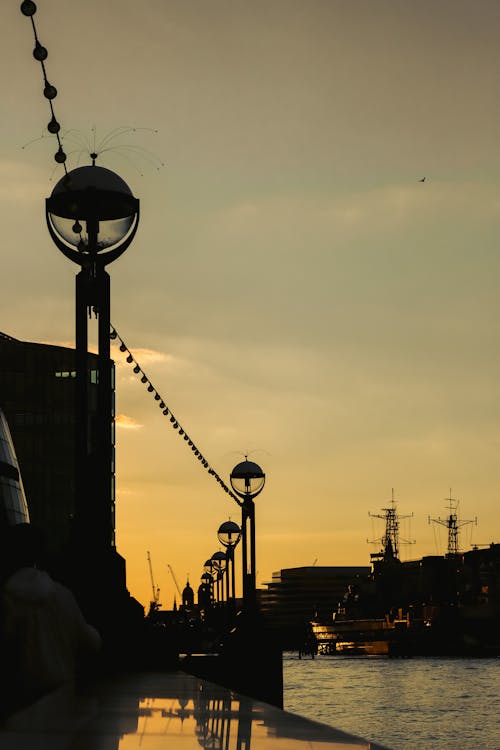 Silhouette of Promenade and Ships in Harbor at Dusk