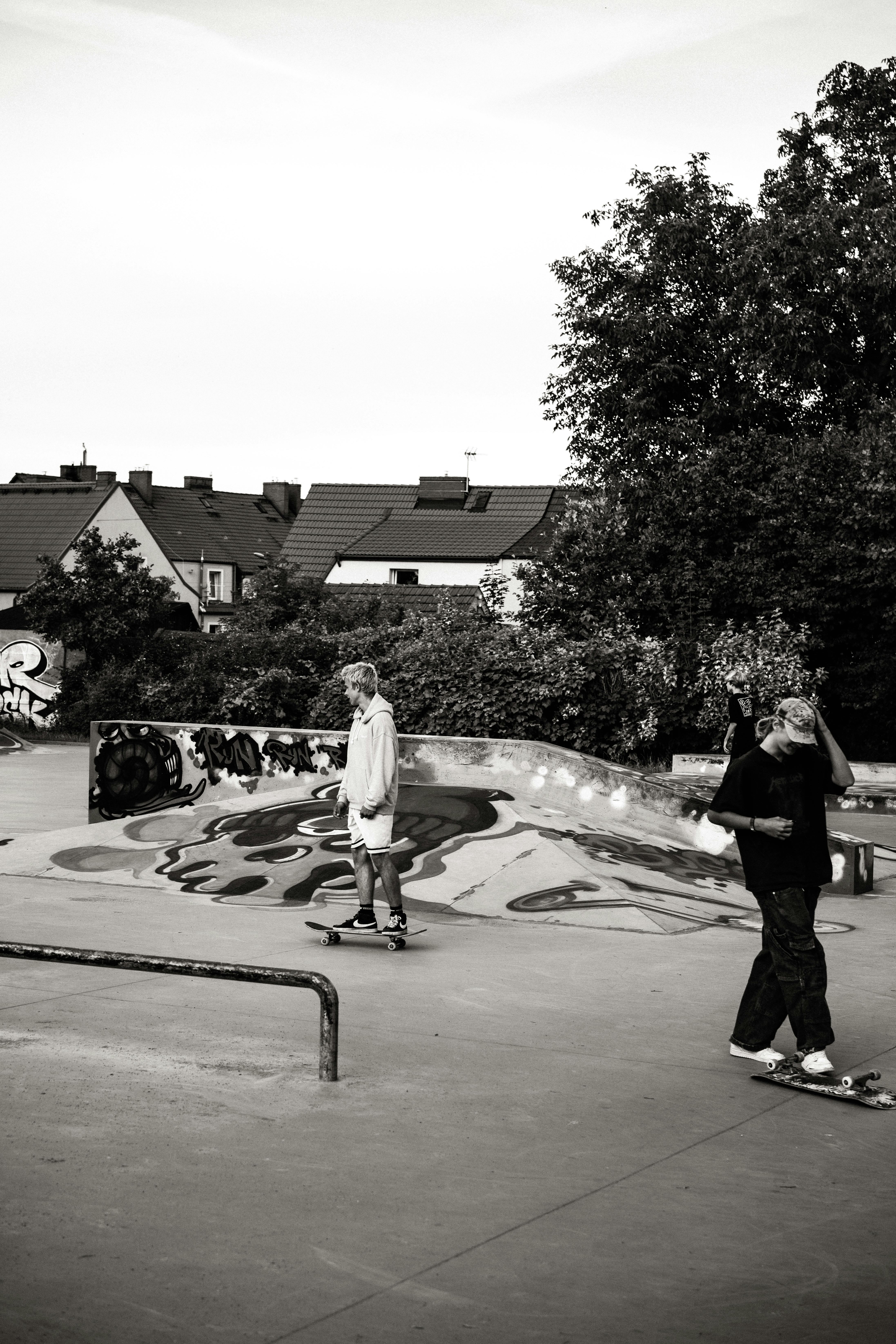 Monochrome image of skateboarders in an urban park, showcasing street culture.