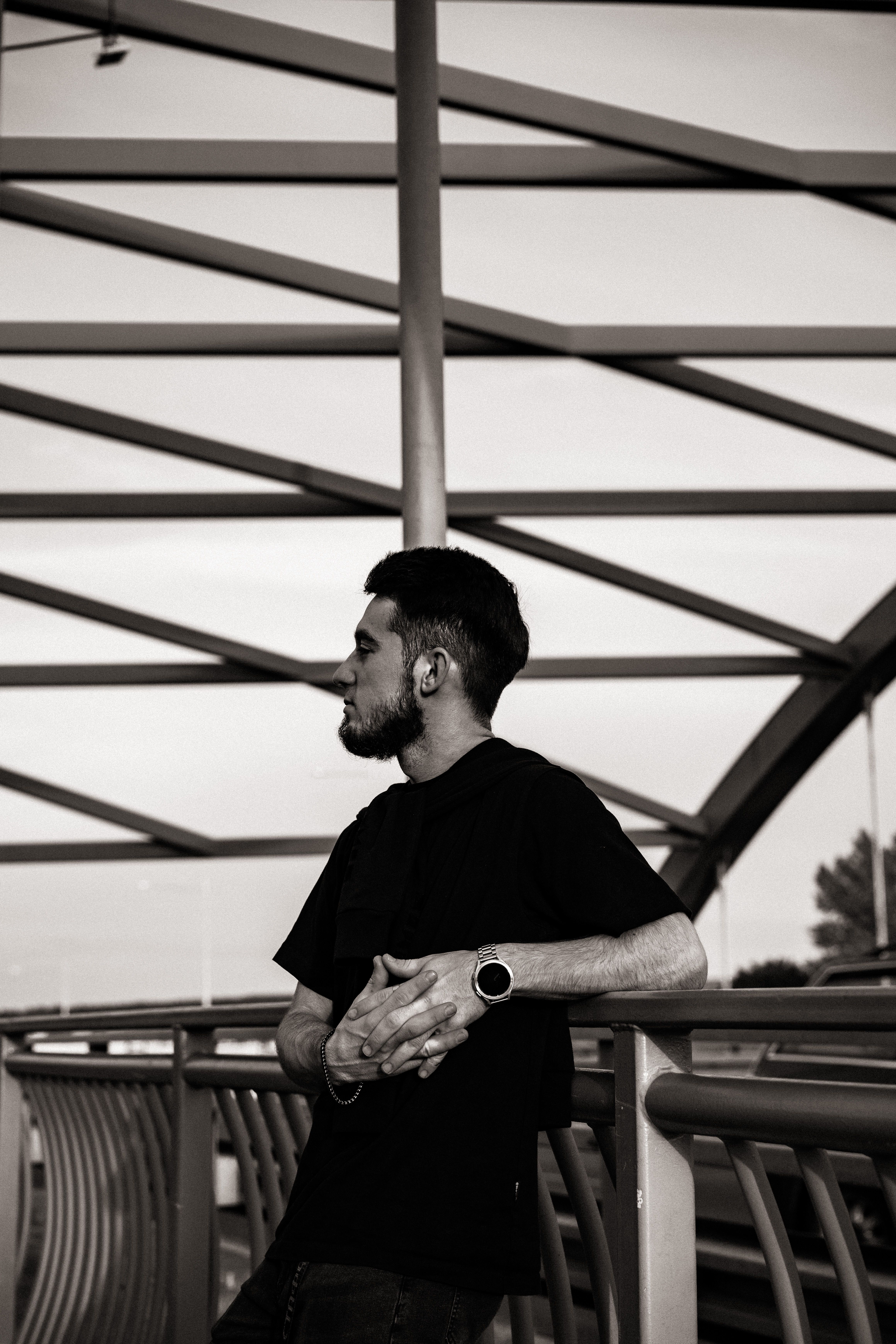 Man Leaning against Bridge Railing with Eyes Closed · Free Stock Photo