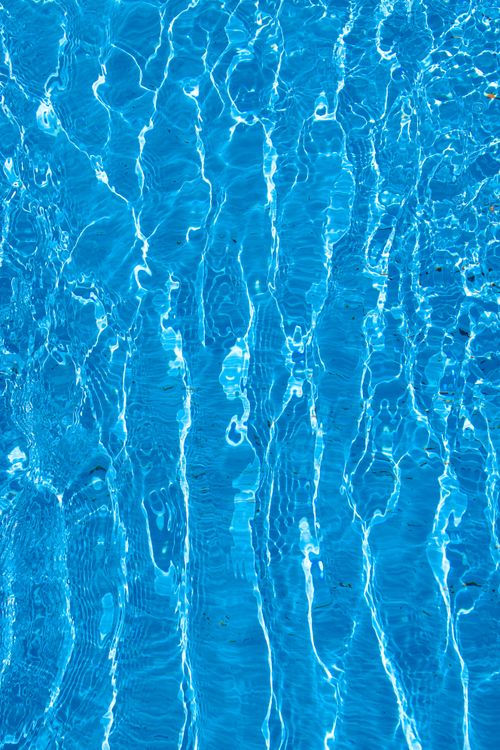 Free Close-up shot of bright and clear swimming pool water with ripples creating an aesthetic pattern. Stock Photo