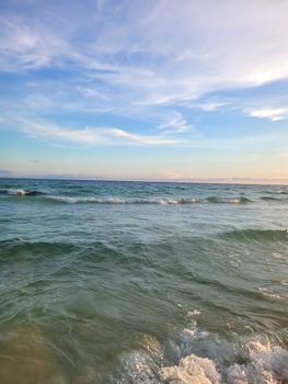 Peaceful view of ocean waves under a picturesque sunset sky, perfect for serene and calm imagery.