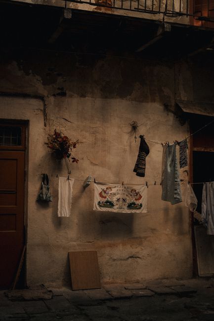Weathered building with laundry on clothesline, showcasing urban rustic charm.