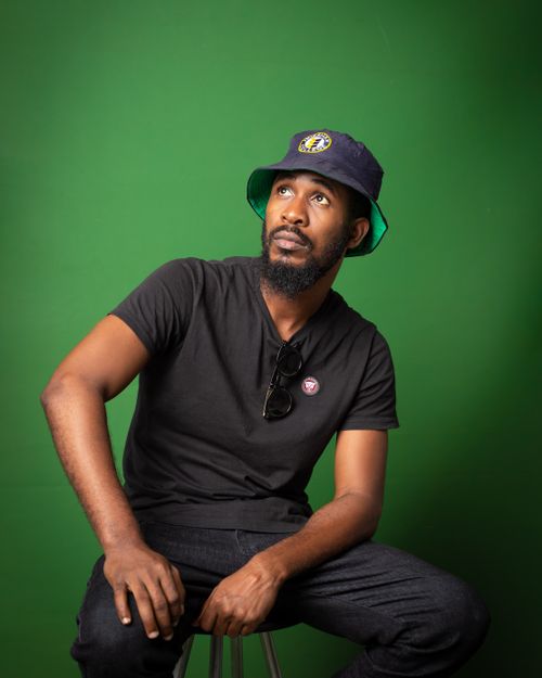 Free Portrait of a man with a beard and hat relaxed with a green background. Stock Photo