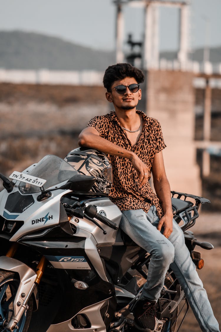 Brunette In Leopard Print Shirt And Jeans Posing With Motorcycle