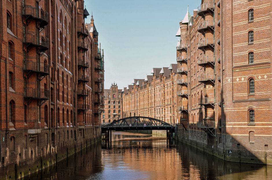 A scenic view of Hamburg's iconic Speicherstadt warehouse district with waterways and historic brick buildings.