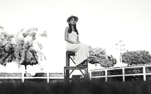 Elegant Woman in a White Dress and a Hat 