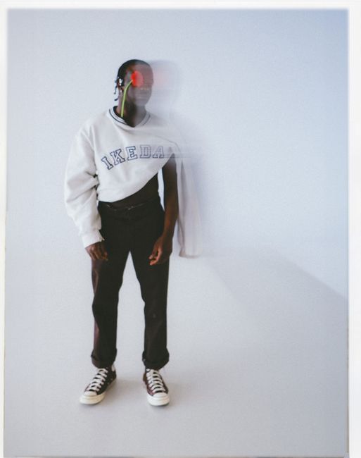 Young man posing in stylish blurred fashion shot with white background.