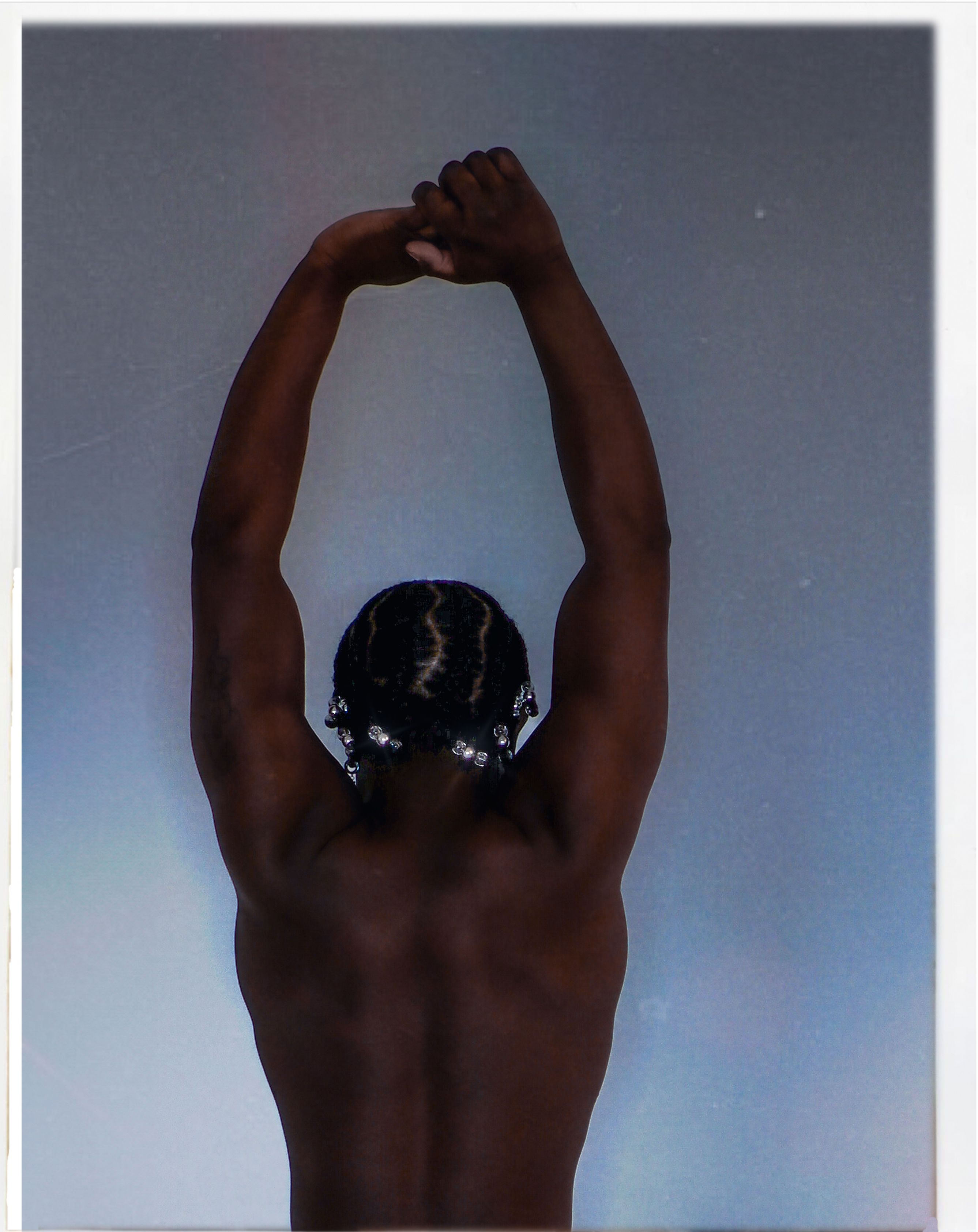 Back View of a Muscular Man Standing with Arms Raised · Free Stock Photo