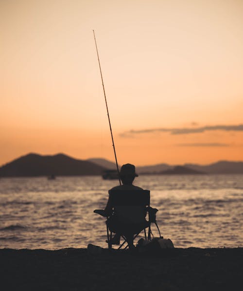 Angler Sitting in Camping Chair by Sea