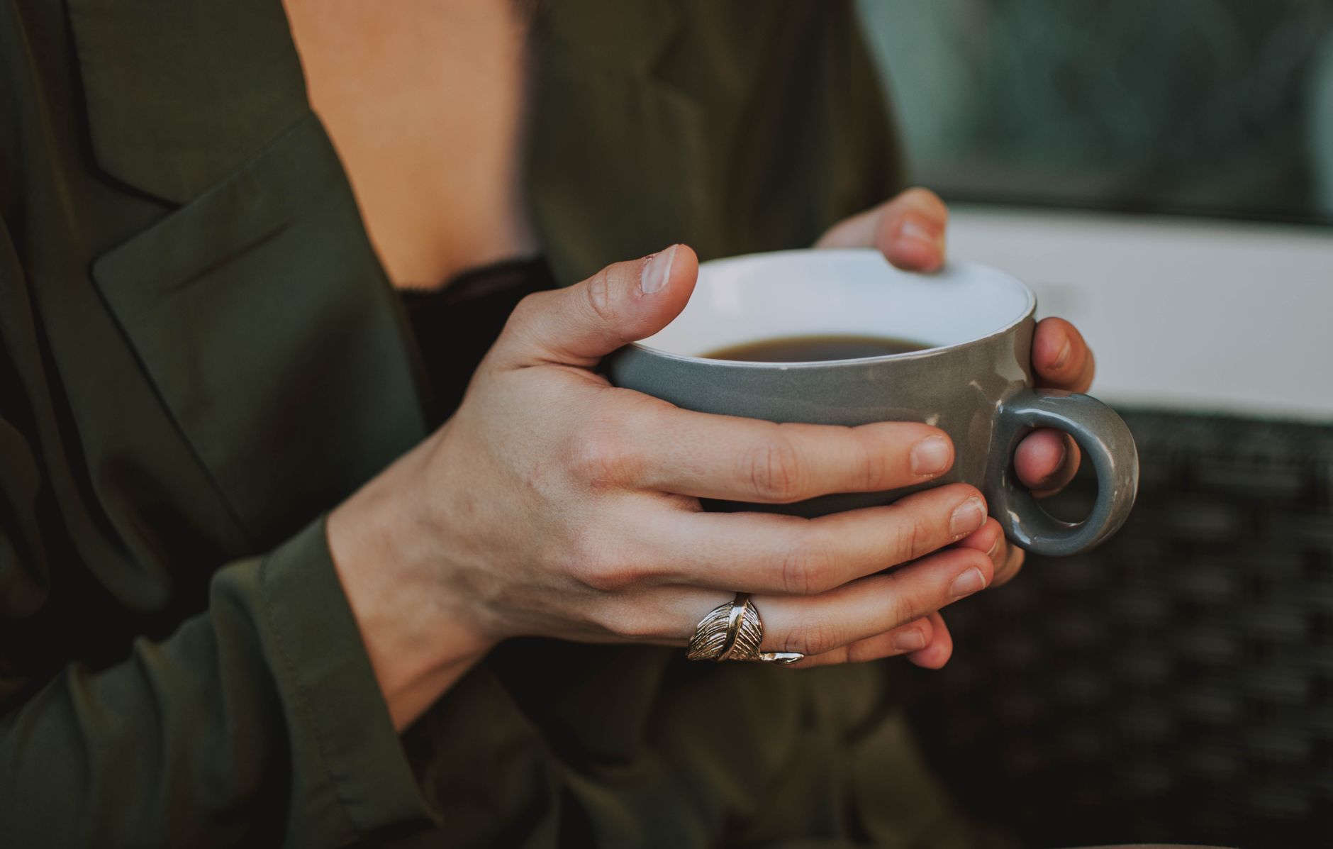 Close-up of a woman holding a warm coffee mug indoors, capturing a cozy moment.. close, woman, holding