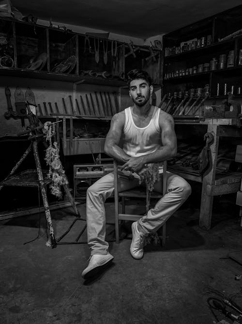 Man in Tank Top Sitting in Workshop