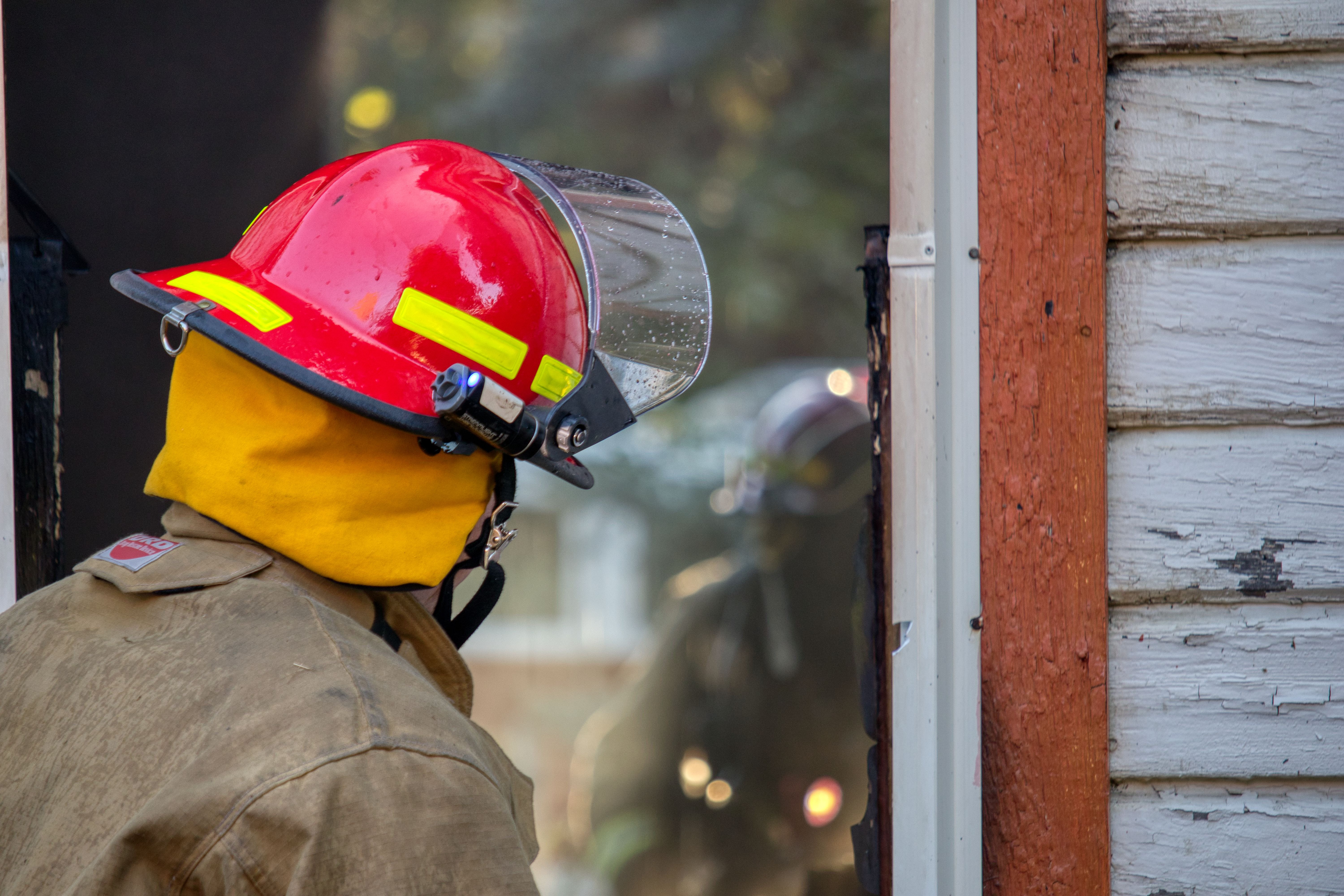 Firefighter Standing by Window · Free Stock Photo