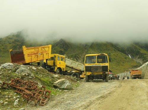 Landscape with Trucks and Fog in Mountains
