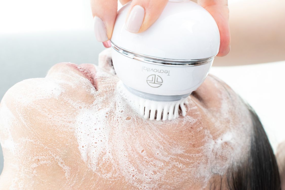 Pessoa recebendo limpeza facial com aparelho elétrico de skincare em contato com a pele