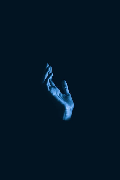 Man Hand Raised in Blue Light