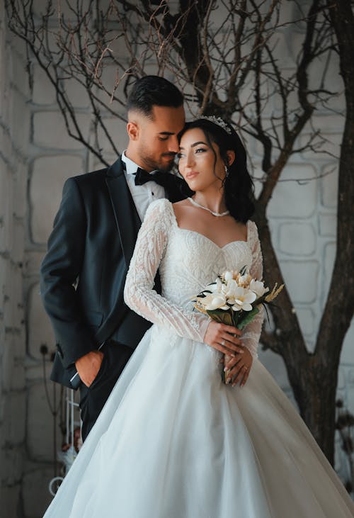 Newlyweds Stand by Bare Tree