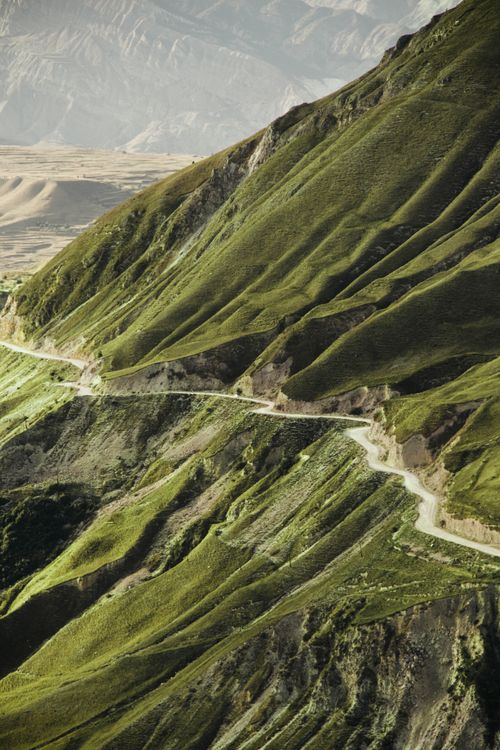 Free Elevated perspective of lush green mountain landscape with winding path. Stock Photo