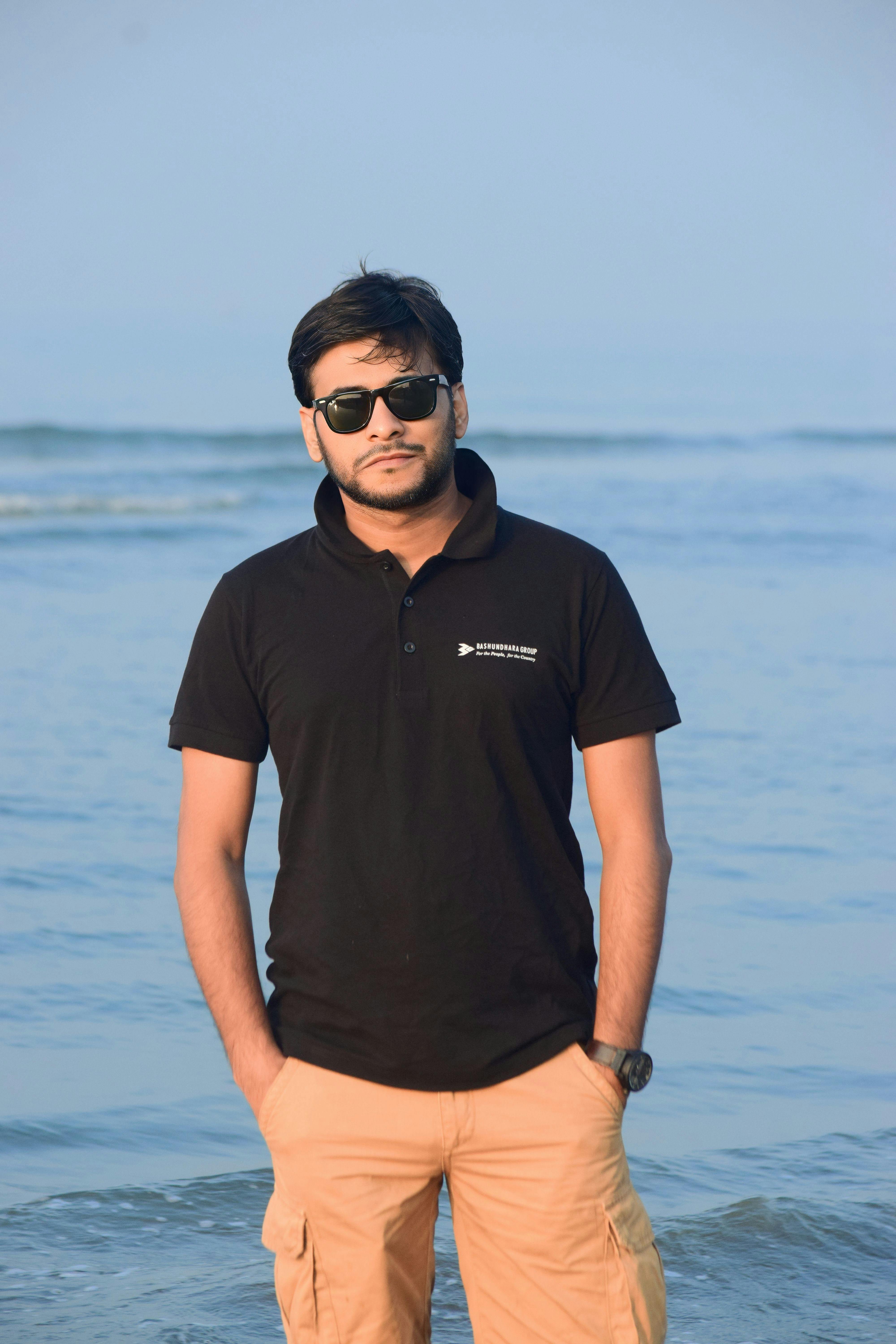 Portrait of a man in black polo standing by the sea at Cox's Bazar, Bangladesh.