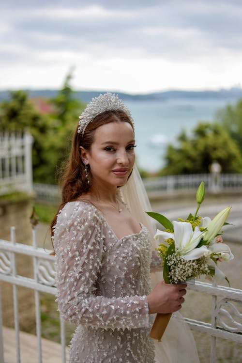 Bride Standing on Terrace and Holding Bouquet