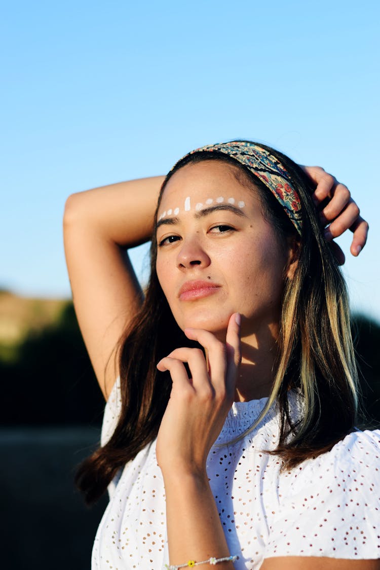 Woman With White Dots Painted On Forehead Touching Chin