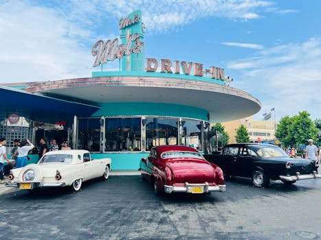 Retro drive-in diner with classic cars in Osaka, Japan, under a clear sky.