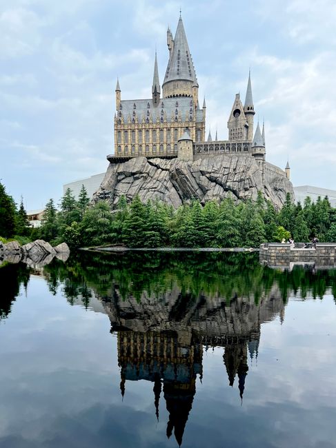 A fantasy castle reflected in the water on the Universal Studios Japan theme park grounds in Osaka
