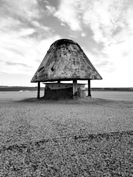 Captivating black and white capture of an abandoned desert structure with dramatic skies.